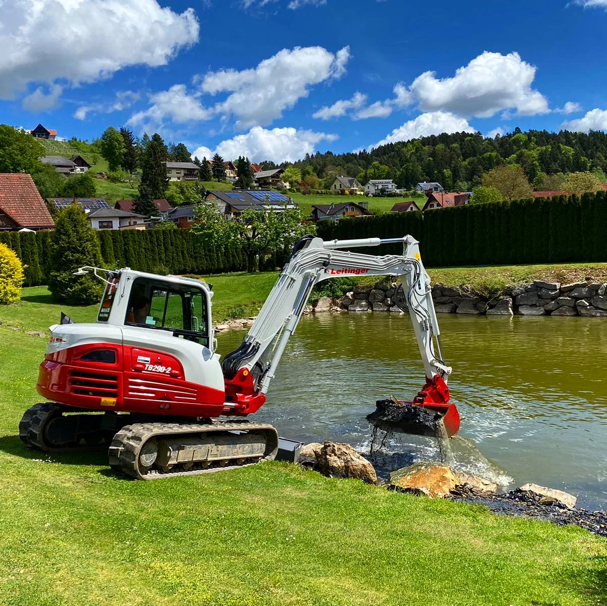 Rot-weißer Leitinger Bagger bei Arbeiten an einem Gartenteich